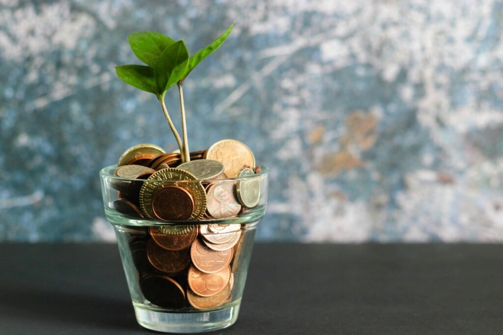 Moedas com planta em vaso de vidro